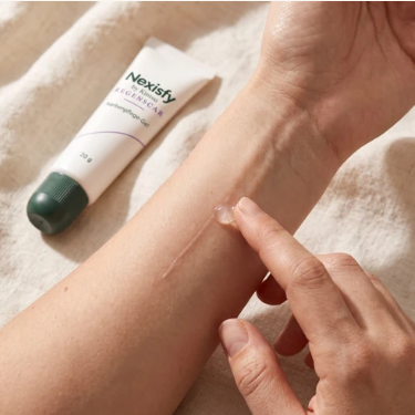 Narbenpflege-Gel neben einer Hand beim Auftragen auf den Unterarm